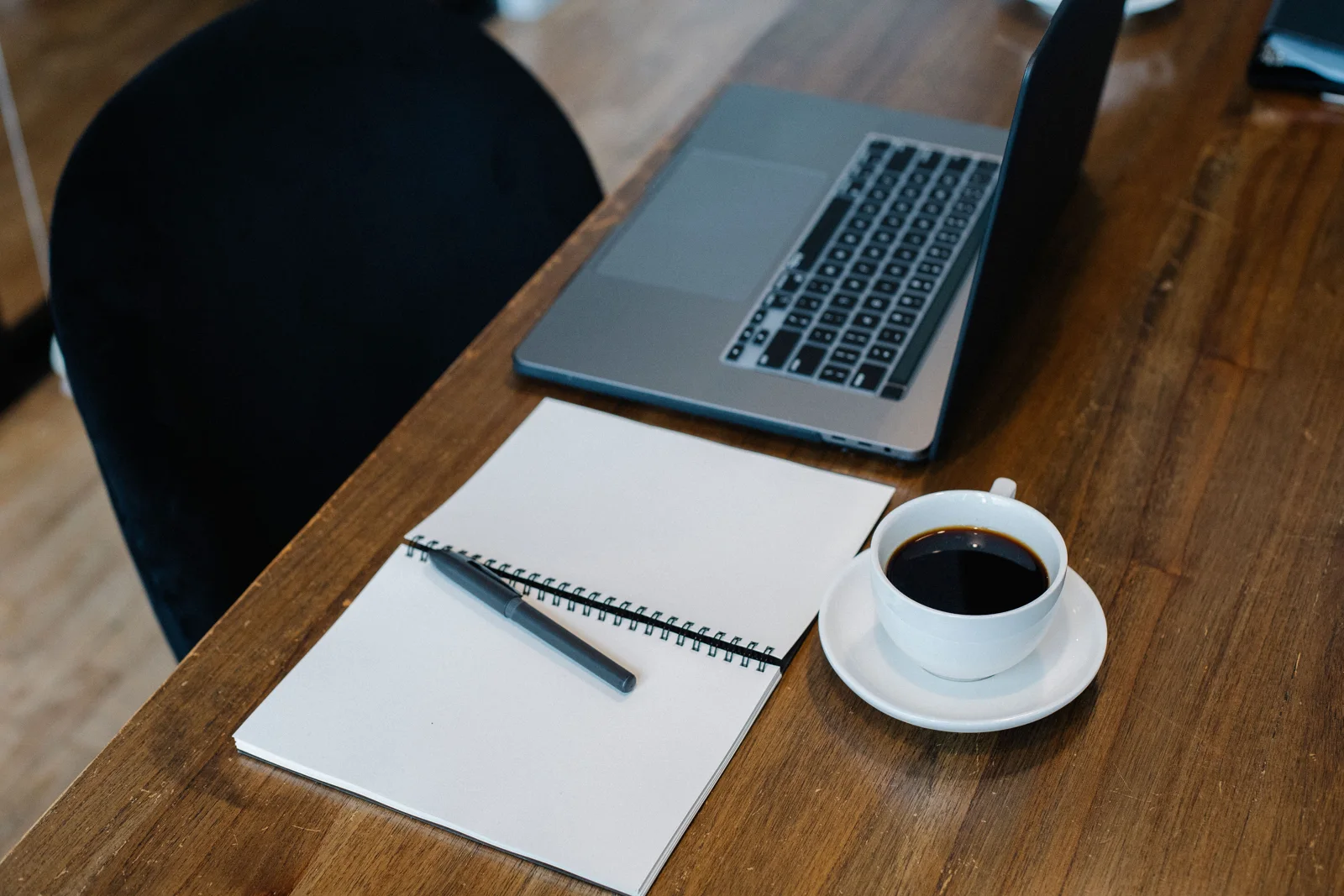 Editorial photograph of a notebook and laptop on a desk